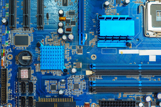 Macro of blue printed circuit board with electronic components and detailed copper traces.