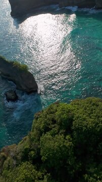 Vertical video. High Speed FPV Drone Dive Above Turquoise Coastal Waters Near Korawa Beach, First Person Flight Past Rocky Formations And Ocean Cliffs, Excitement And Exploration