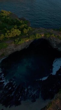 Vertical video. Smooth Aerial Flight Around Broken Beach During Golden Hour, Wide Angle View Of Ocean Cliffs And Natural Coastal Formation, Serenity And Tropical Adventure