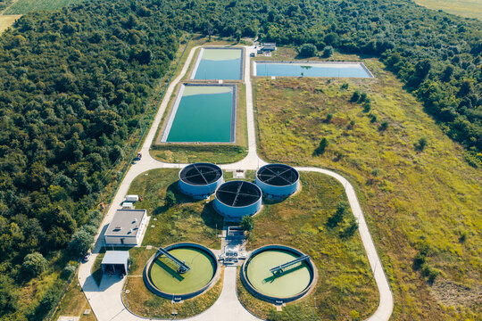 Aerial view of the Telavi Waste Water Treatment Facility featuring circular sedimentation tanks and rectangular treatment ponds surrounded by lush greenery in Kondoli, Kakheti, Georgia.