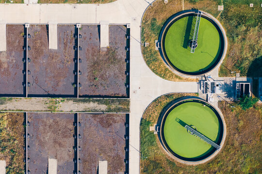 Aerial view of the Telavi Waste Water Treatment Facility featuring circular sedimentation tanks with green water and rectangular filtration basins in Kondoli, Kakheti, Georgia.