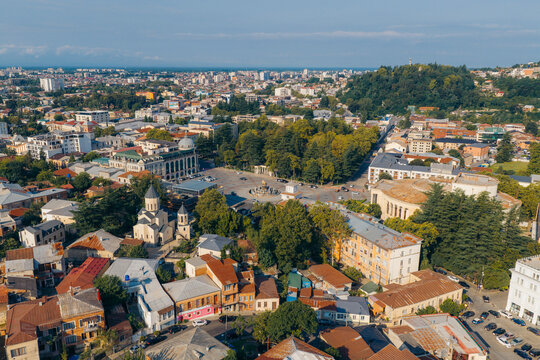 Aerial view of the Colchis Fountain in the central square surrounded by historic buildings and lush trees in Kutaisi, Imereti, Georgia.
