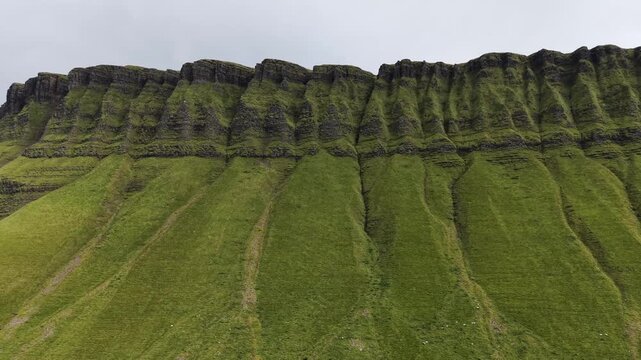Aerial drone view of the majestic Benbulben mountain cliffs with green slopes in County Sligo, Ireland.