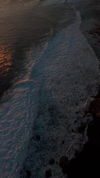 Vertical video. Extreme FPV Drone Dive Along Karang Boma Cliff At Sunset, First Person Descent Above Powerful Ocean Waves And Rocky Shoreline, Adrenaline And Freedom