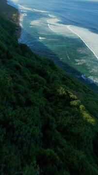 Vertical video. Extreme FPV Drone Dive Along Nyang Nyang Beach Clifftop, High Speed Descent Above Tropical Coastline And Powerful Ocean Waves, Adrenaline And Precision Flight Through Rugged Terrain