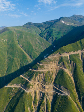 Aerial view of the winding Abano Pass road carved into the steep green slopes of the Caucasus Mountains in Akhmeta Municipality, Kakheti, Georgia.