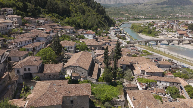 Aerial view of the historic city of Berat with traditional Ottoman-style houses, terracotta rooftops, the Osum River, and the stone Gorica Bridge in Berat, Berat County, Albania.