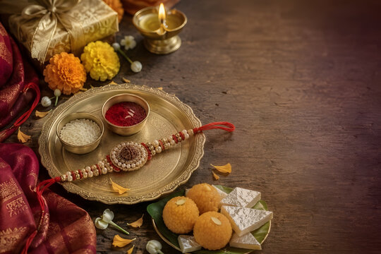 Raksha Bandhan Celebration with Traditional Rakhi, Brass Puja Thali, Kumkum, Rice, Diya and Indian Sweets