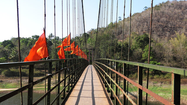 The saffron-flagged suspension bridge across the Periyar River at Ayyappankovil in Idukki, Kerala, India