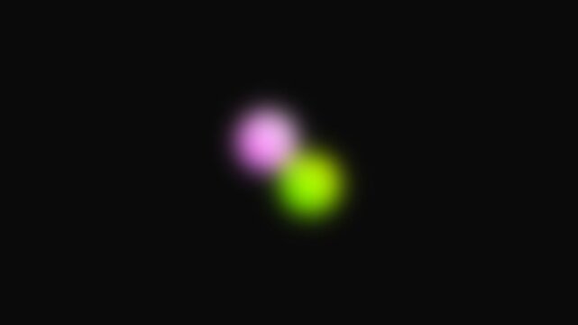 Blurred glowing spots in pink and green overlap softly on a pitch black backdrop.
