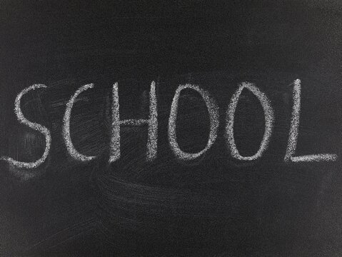 Blackboard with the handwritten word 'school'. School concept.