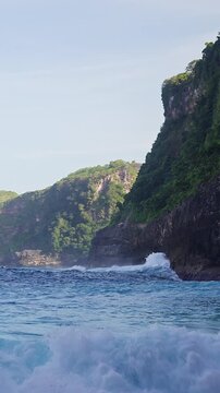 Vertical video. Powerful Ocean Wave Breaking Along the Coastline Below Kelingking Beach on Nusa Penida Island Indonesia