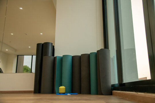 Rolled fitness yoga mats standing in corner of gym fitness studio