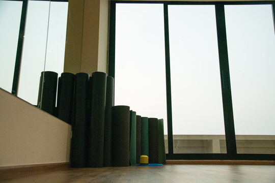 Rolled fitness yoga mats standing in corner of gym fitness studio