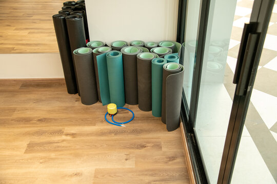 Rolled fitness yoga mats standing in corner of gym fitness studio