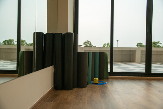Rolled fitness yoga mats standing in corner of gym fitness studio