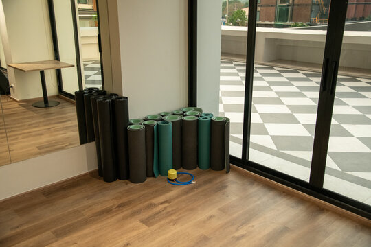 Rolled fitness yoga mats standing in corner of gym fitness studio