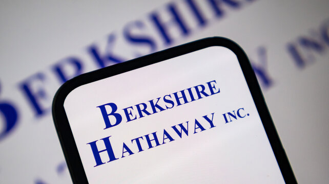 Berkshire Hathaway logo displayed on smartphone screen with blurry background.