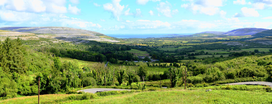The view from Corkscrew Hill over the green valley in the area of The Burren in County Clare, Ireland, with a view of Galway Bay.