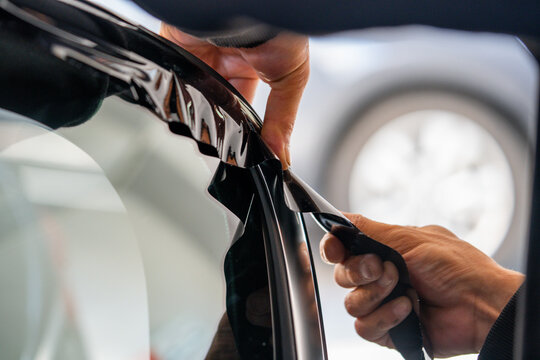 A car wrapping specialist applies a polyurethane film to the car. Detailer PPF
