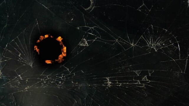 fiery burning through the black surface of cracked old black glass, transparent video template without a background for applying the burning effect, alpha channel