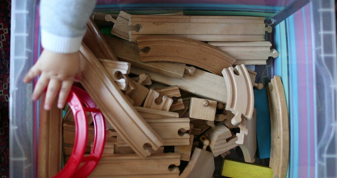 Baby child hand choosing toy from box, seen from above