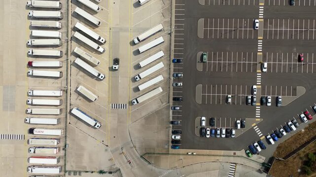 Top down aerial view of parked cars and HGV lorries lined up at logistics distribution centre Luton UK