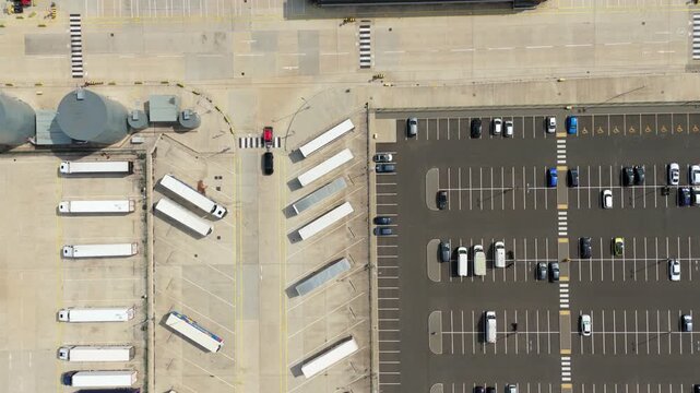 Top down aerial view of parked cars and HGV lorries lined up at logistics distribution centre Luton UK
