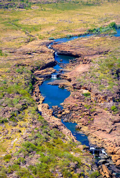 Aerial view reveals Mitchell Plateau and lower Mitchell Falls in Western Australia surrounded by rugged terrain and flowing water