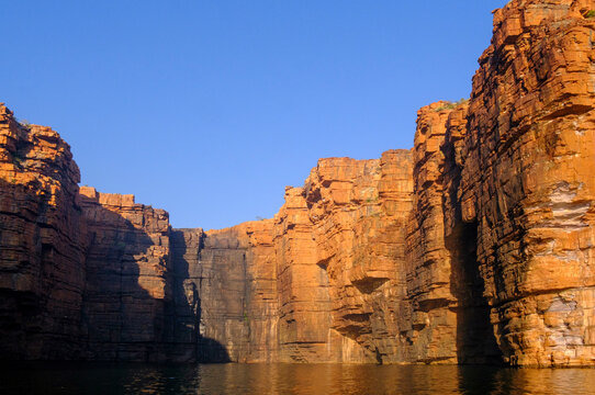 Warton Sandstone cliffs illuminated by sunrise over King George River in the Kimberley region of Australia