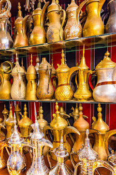 Traditional tea pots displayed in a market in Oman featuring various designs and materials from local artisans