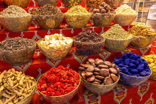 Variety of spices displayed in clear bowls at a market stall in Muscat