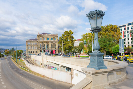 Neo-Renaissance building of the Hungarian Academy of Sciences on a busy street in Budapest with lamp post and trees nearby