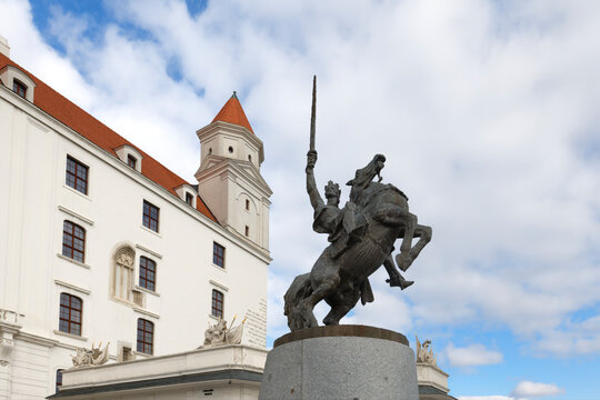 King Svatopluk statue in front of Bratislava castle with blue sky and clouds in the background