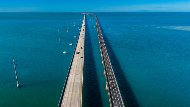 Driving along the 7 mile bridge on Highway Number 1 with boats and ocean in view in Florida Keys