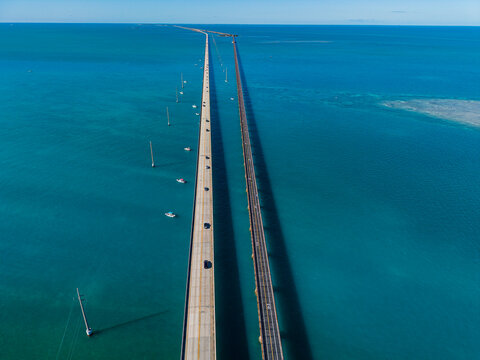 Views from 7 mile bridge along Highway Number 1 over turquoise water in the Florida Keys with vehicles and boats below