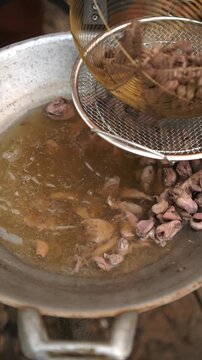 Cooking Thai stir-fried chicken entrails with holy basil (Phad Ka Prao Khreuang Nai Gai). Blanching chicken entrails, saut&eacute;ing chili and garlic, tossing with entrails, seasonings, and holy basil.