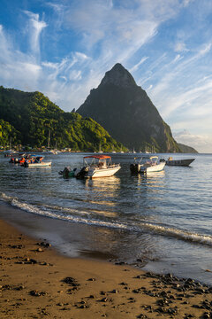 Boats in calm waters with the Pitons in the background during sunset in Soufriere, Saint Lucia