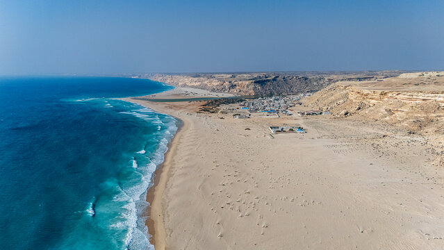 Sand dunes meet the Indian ocean in Eyl with coastlines and distant hills, depicting an arid scene in Puntland, Somalia