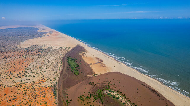 Aerial view of a long beach with the Juba river flowing into the Indian Ocean in Kismayo, Jubaland, Somalia