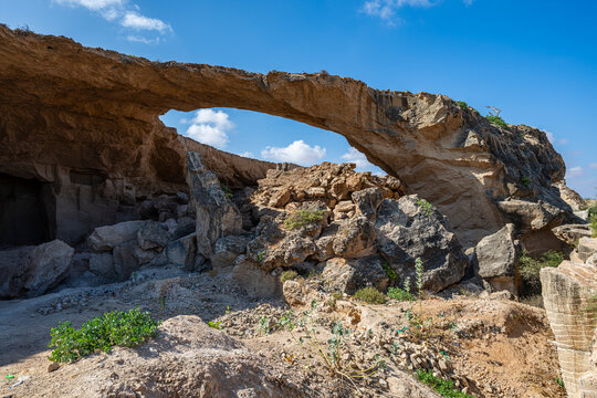 Stone arch spans a quarry with rocky terrain and clear sky above in Kismayo, Jubaland, Somalia