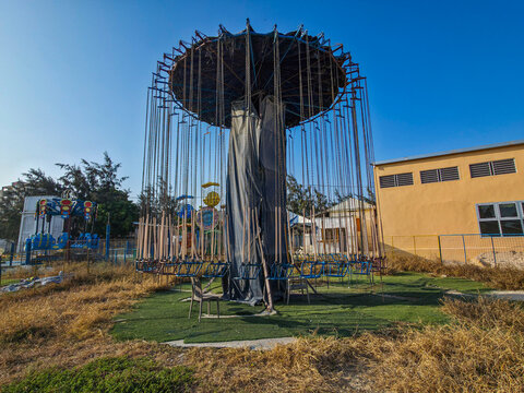 Swing ride in amusement park features tall structure and seats at Mogadishu's outdoor attractions during sunny day