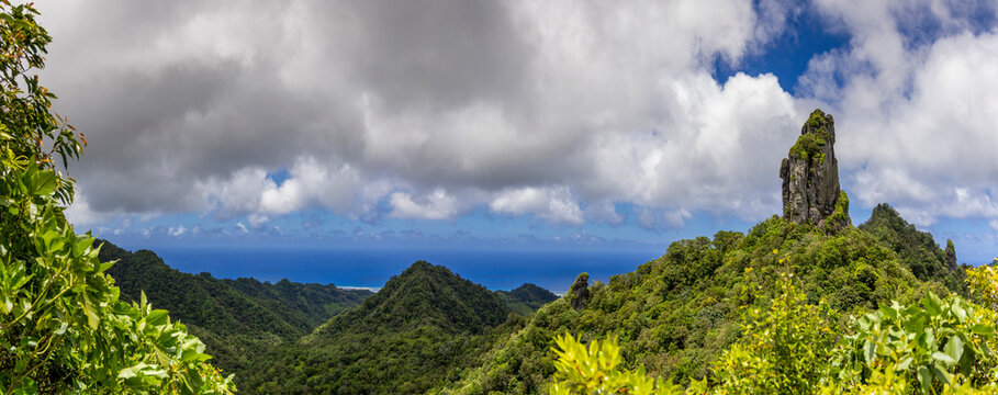 Views from the Cross Island hike toward the Needle rock formation on Rarotonga Island with greenery and ocean in the background