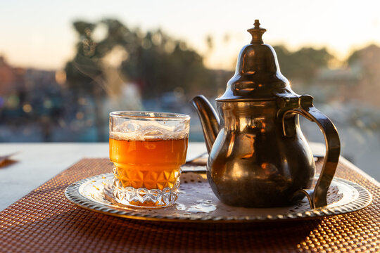 Traditional mint tea served in a teapot with a glass at sunset in Morocco
