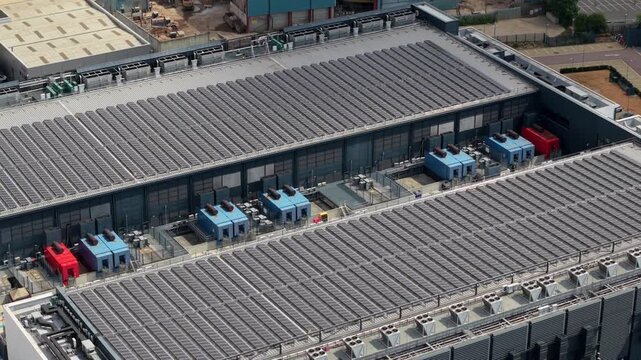 Aerial view of a hyperscale cloud data center with rooftop solar panels and central rows of industrial cooling chillers in Hemel Hempstead, UK