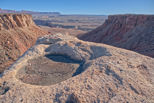 Stone bowl on cliffs at Soap Creek Mesa with wide view of landscape below in Vermilion Cliffs National Monument Arizona