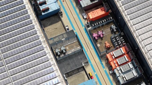 Aerial view of a hyperscale cloud data center with rooftop solar panels and central rows of industrial cooling chillers in Hemel Hempstead, UK