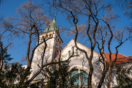 Gothic Revival Church of Saint Elizabeth visible through trees in Bratislava with clear skies and architectural details