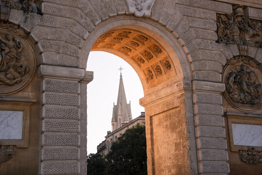 Porte du Peyrou arch frames church spire in Montpellier, built in 1691 to honor Louis XIV and mark the entrance to royal square