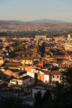 Rooftop view of Granada at golden hour with the Cathedral and Sierra Nevada in the background